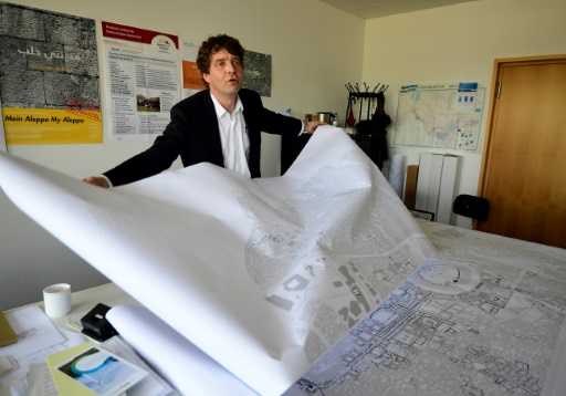 L&rsquo;urbaniste Christoph Wessling montre la carte de la ville syrienne d&rsquo;Alep, détruite par la guerre, le 17 mai 2017 à l&rsquo;université de Cottbus