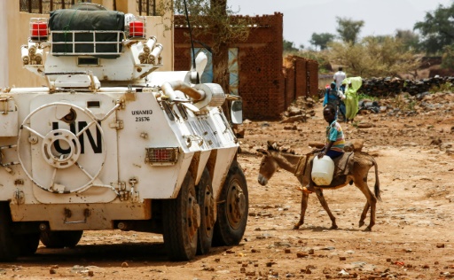 Un enfant sur son âne passe devant un blindé de la mission de maintien de le paix au Darfour (Minuad)