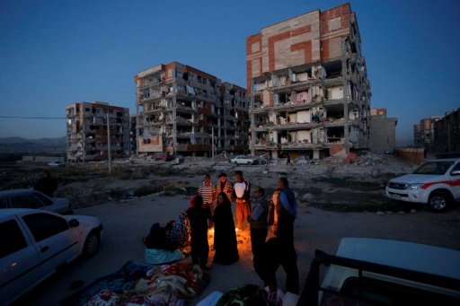 Des Iraniens se réchauffent près d’un feu