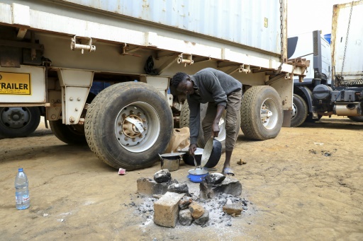 L'assistant d'un chauffeur routier prépare un repas entre des camions bloqués à Garoua Boulaï, à la frontière entre la Centrafrique et le Cameroun, le 8 janvier 2021. © AFP Daniel Beloumou Olomo
