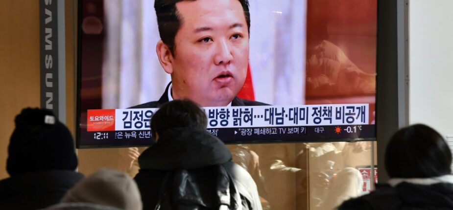 Des personnes regardent une chaîne d'info montrant une photo du leader nord-coréen Kim Jong Un lors d'une réunion du parti au pouvoir à Séoul le 1er janvier 2022
