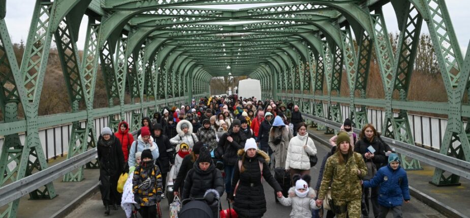 Des réfugiés ukrainiens franchissent un pont frontalier avec la Pologne, le 6 mars 2022