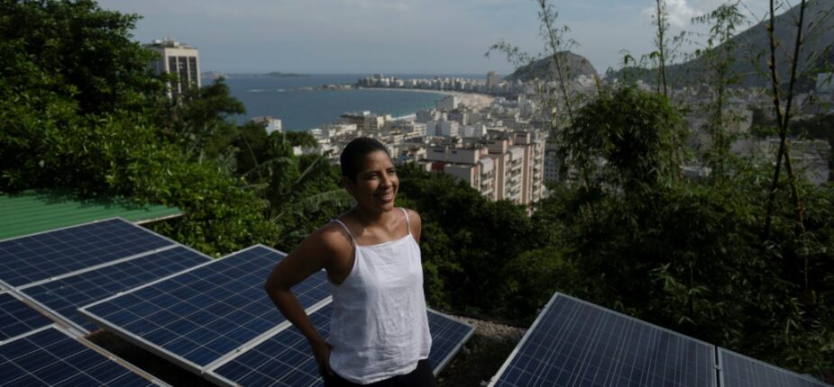 La Colombienne Bibiana Angel, propriétaire d'une auberge de jeunesse, pose sur le toit de l'établissement équipé de panneaux photovoltaïques, le 8 avril 2022 à Babilonia, une favela de Rio de Janeiro