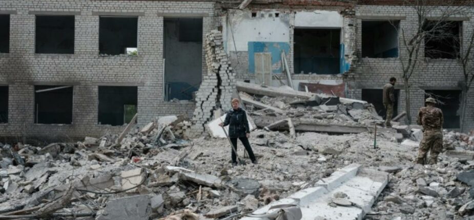 Yarvoslava (au centre), 51 ans, qui pense que son mari est sous les débris, creuse avec une pelle dans les ruines d'un bâtiment détruit à Sydorove, dans l'est de l'Ukraine, le 17 mai 2022