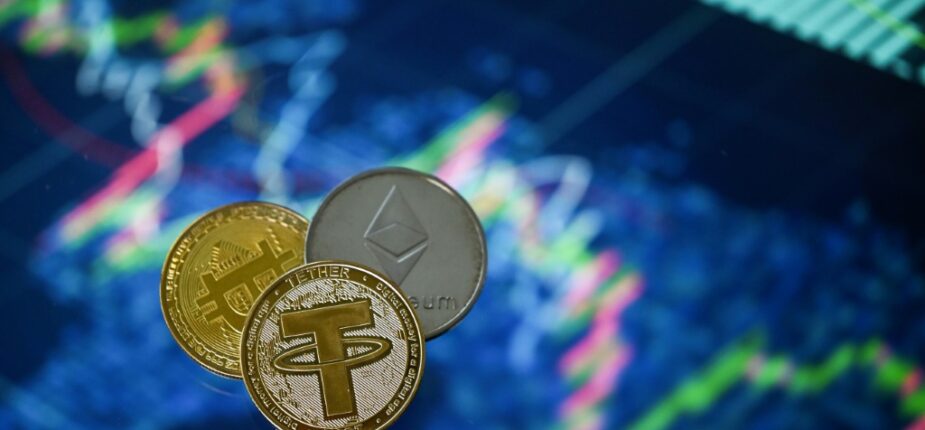 Des pièces souvenir reproduisant les logos du Tether, du bitcoin et de l'Ethereum photographiées à Londres, le 8 mai 2022