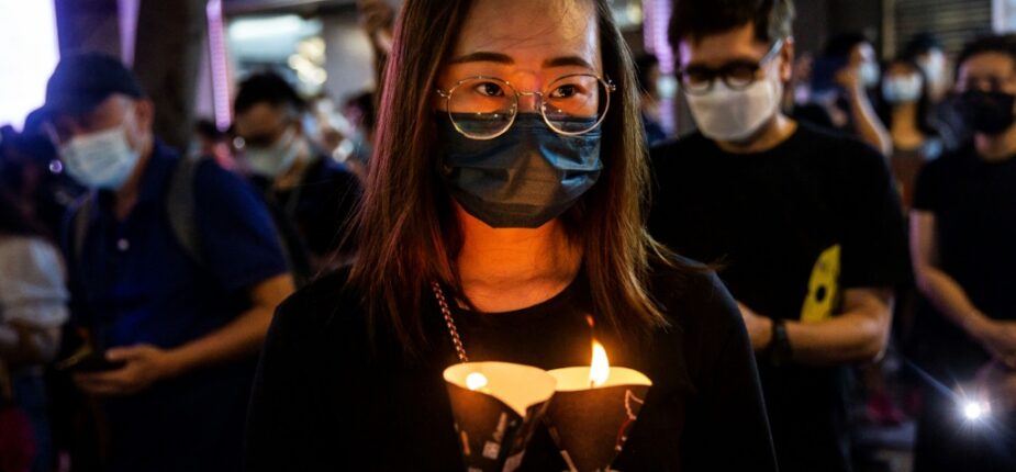 Une femme tient une bougie lors de la veillée en souvenir de Tiananmen le 4 juin 2021 à Hong Kong