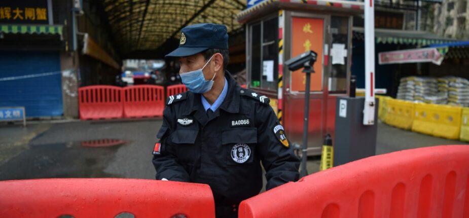 Un policier devant le marché fermé de Wuhan où le coronavirus a été détecté, le 24 janvier 2020 en Chine