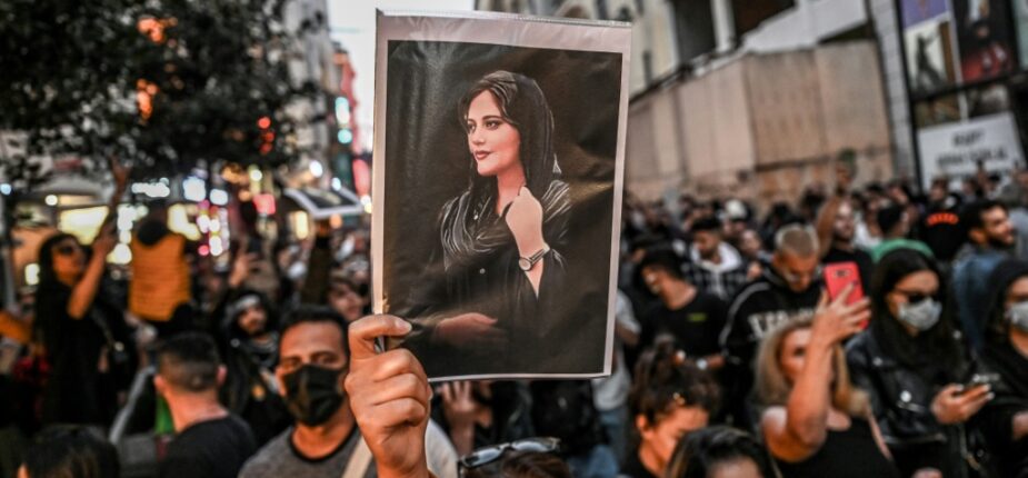 Une manifestante tient un portrait de Mahsa Amini lors d'une manifestation en hommage à cette jeune femme iranienne décédée après avoir été arrêtée à Téhéran par la police des mœurs de la République islamique, sur l'avenue Istiklal à Istanbul, le 20 septembre 2022