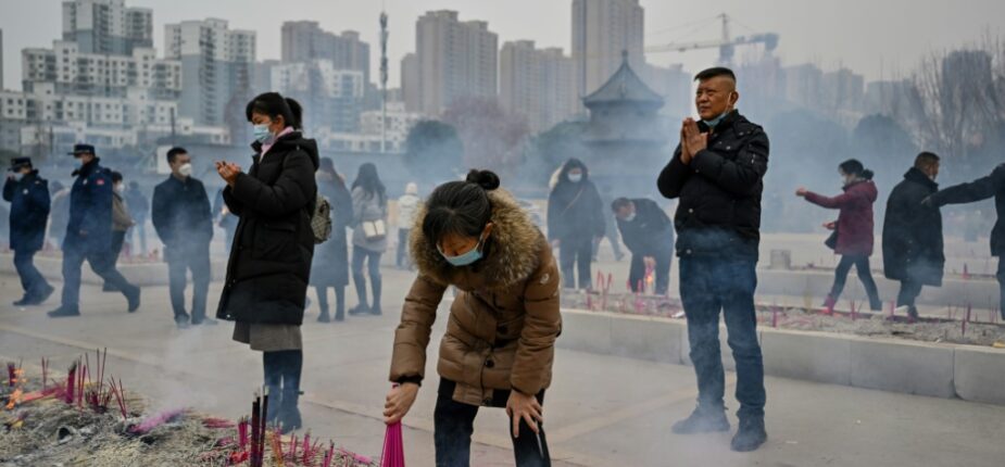 Une femme brûle des bâtons d'encens au temple bouddhiste de Guiyuan à Wuhan, dans le centre de la Chine, le 23 janvier 2023