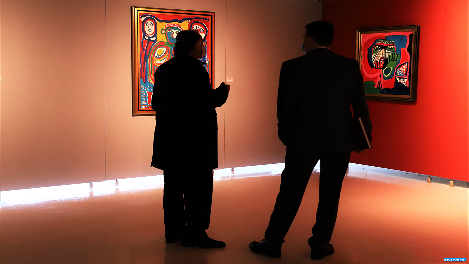 Des invités méditent des toiles lors du vernissage de l’exposition Chaibia Talal la magicienne des arts