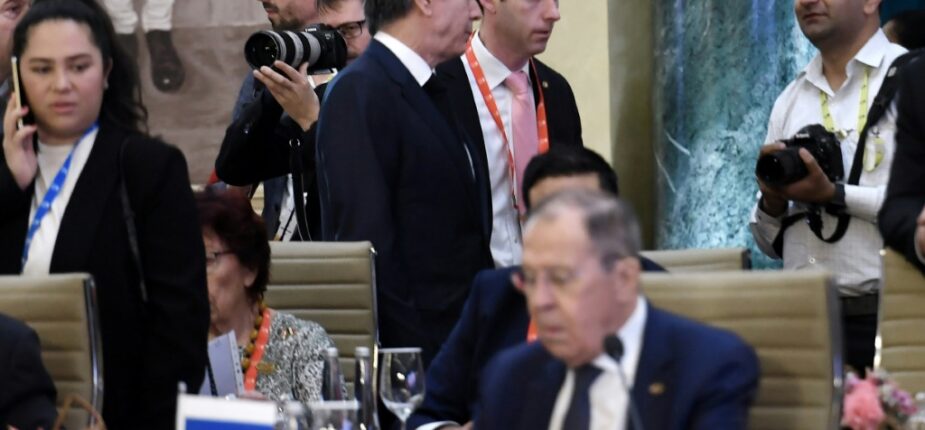 Le secrétaire d'Etat américain Antony Blinken (en haut, au centre) passe près du ministre russe des Affaires étrangères Sergueï Lavrov (au premier plan), le 2 mars 2023 lors d'une réunion du G20 à New Delhi