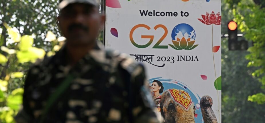 Un agent de sécurité monte la garde à côté d'une pancarte installée dans une rue de New Delhi avant le sommet de deux jours du G20, le 5 septembre 2023