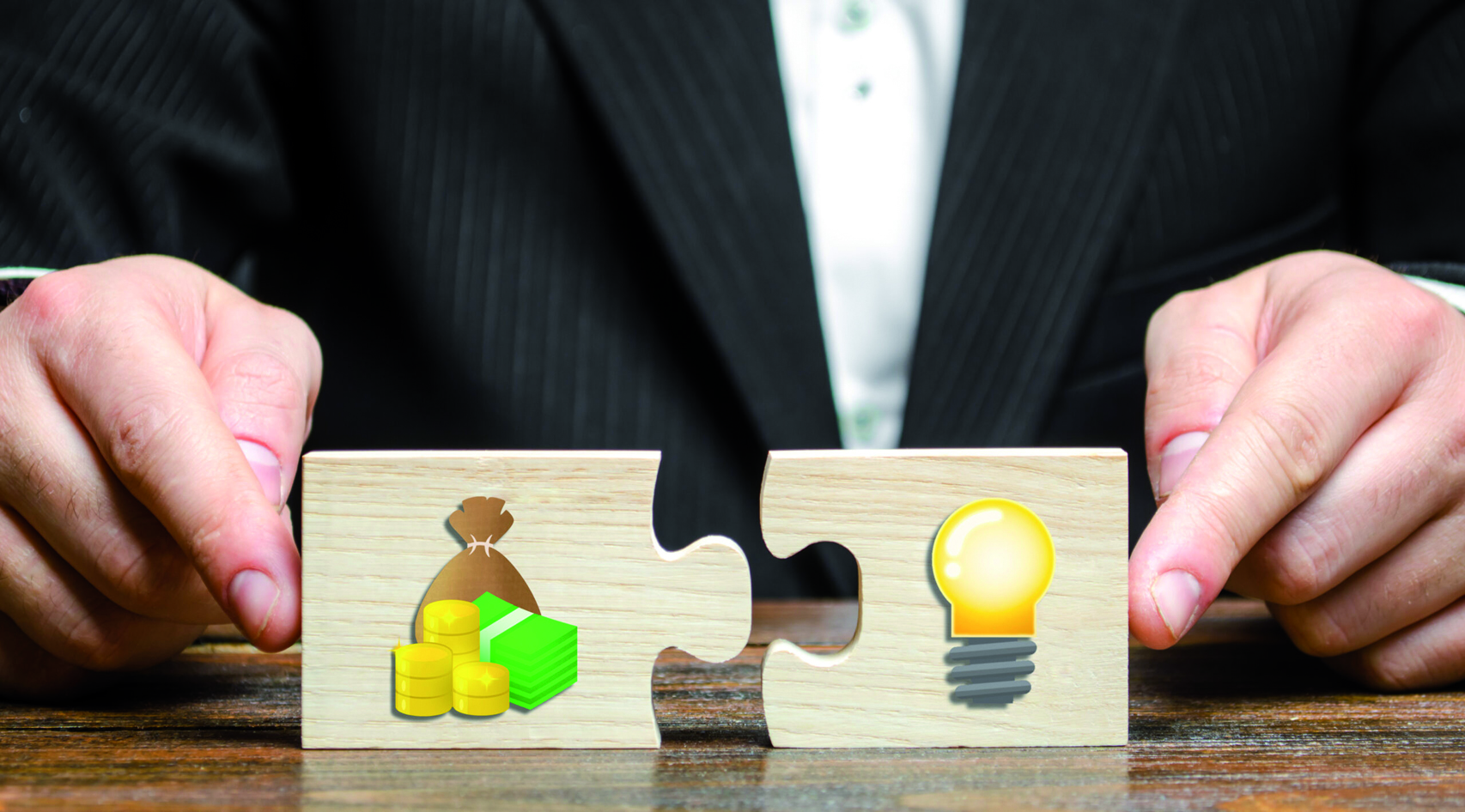 Businessman,Puts,Two,Puzzles,With,The,Image,Of,Money,And